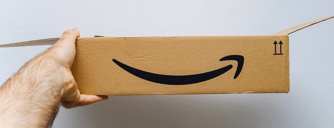 Amazon cardboard box against white background in hand